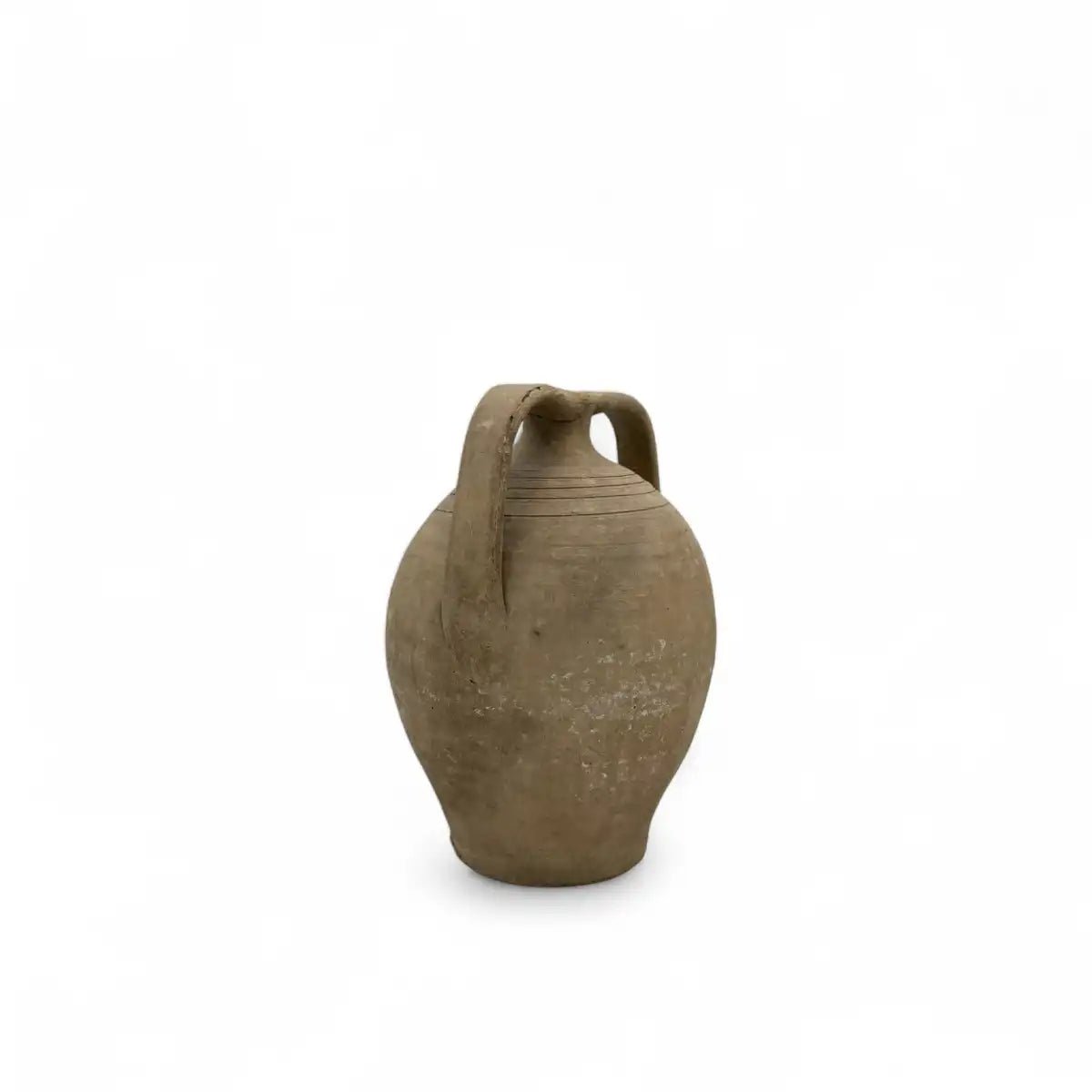 L'anfora Spirito Mediterraneo in un salotto bohémien, accanto a piante e tessuti naturali.