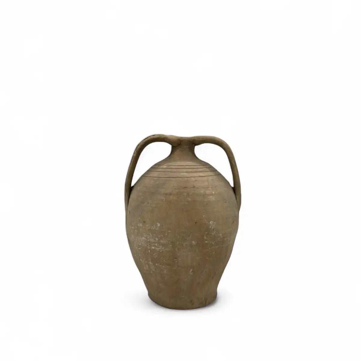 Dettaglio della forma pura ed essenziale dell'anfora in terracotta, che mostra la fattura manuale.