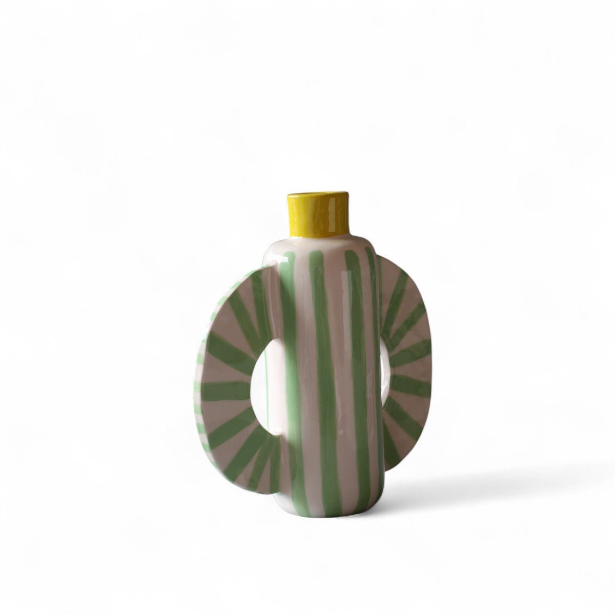 Dettaglio delle linee verdi verticali e dei ventagli laterali del vaso scultoreo.