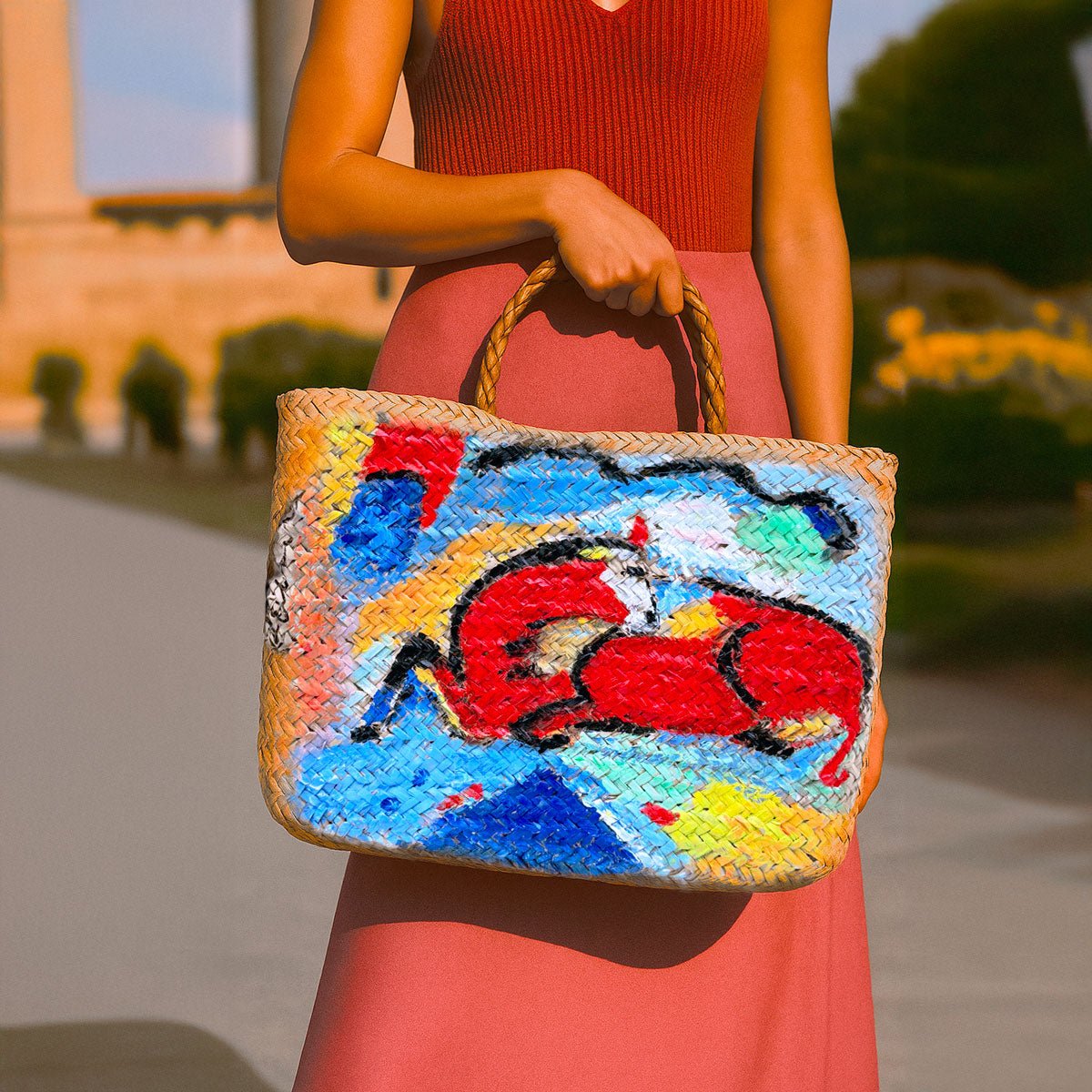 Primo piano del dipinto del toro rosso in stile modernista sulla borsa in paglia.