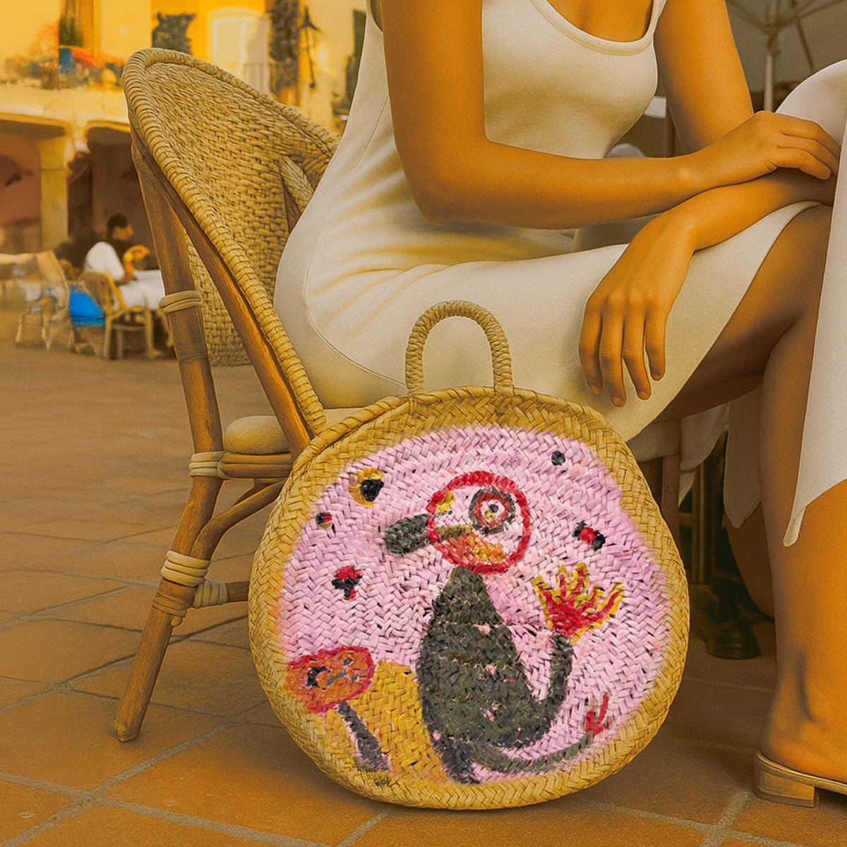 Modella indossa la borsa in paglia Porto Cervo con un abito elegante in Costa Smeralda.