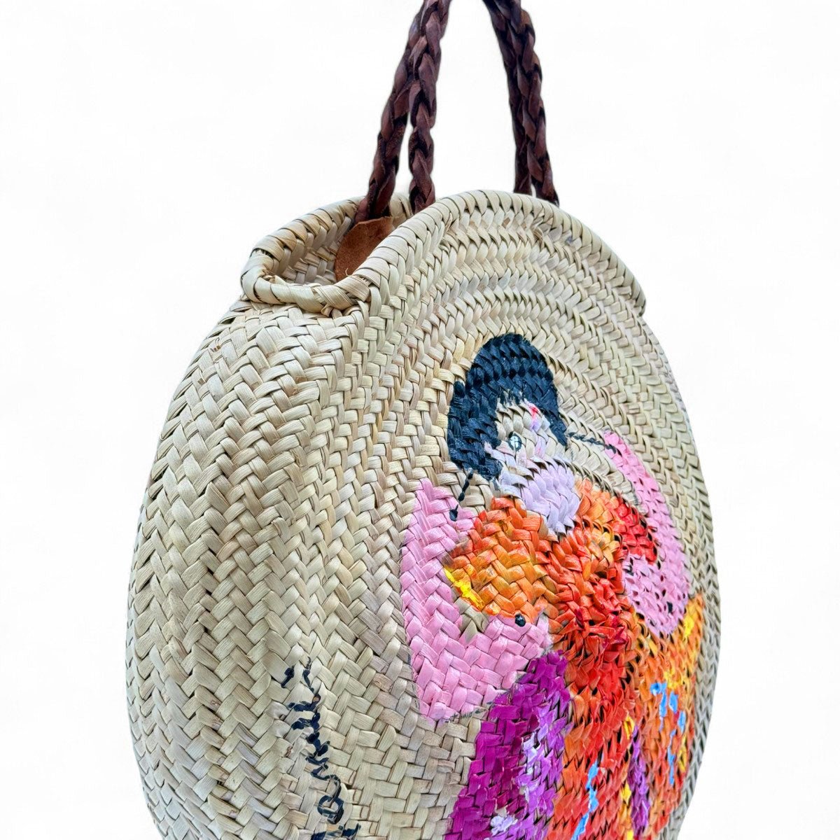 Profilo della borsa in paglia rotonda che ne mostra la generosa capienza.