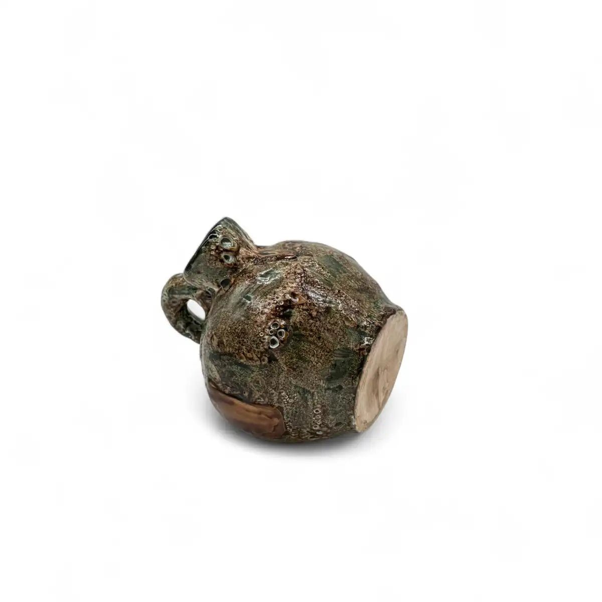 Mano che sfiora la superficie liscia e lucida del botijo in ceramica, evidenziando la fattura.