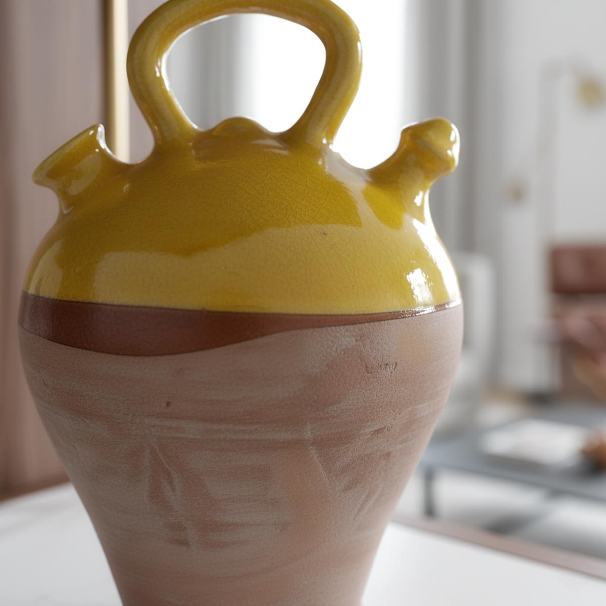 Primo piano dello smalto color miele, denso e vibrante, sulla parte superiore del botijo vintage.