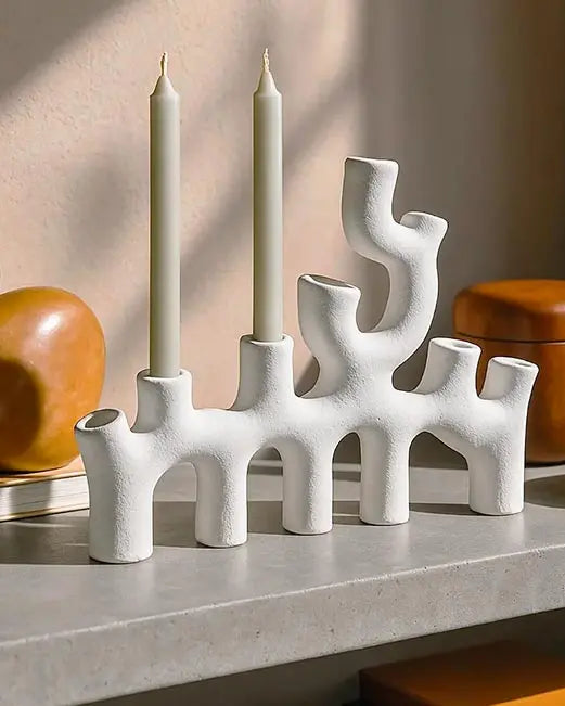 candelabro di design in ceramica bianca sopra una mensola in un interno moderno