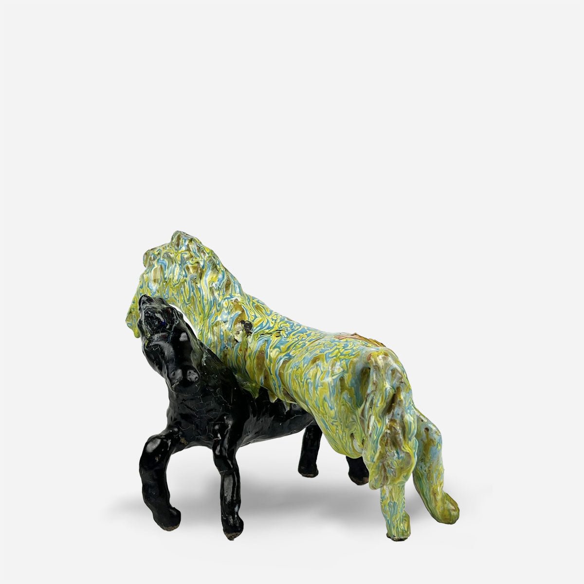 Le due figure della scultura cavalli selvaggi esposte su una libreria in legno.