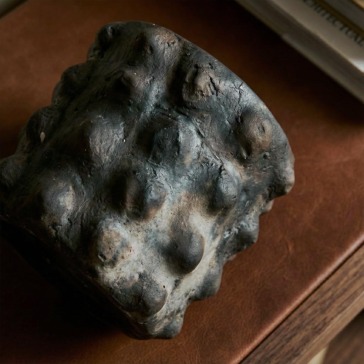 Particolare della lavorazione artigianale a rilievo sul vaso cilindrico nero