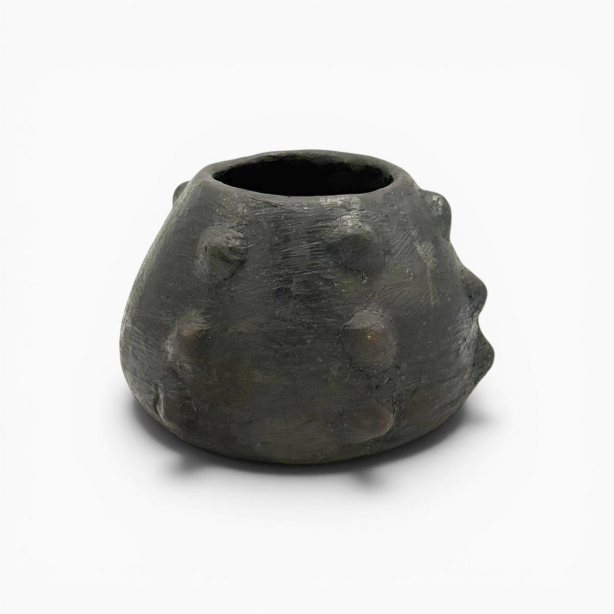 Finitura nero fumo e sfumature cenere, segni della cottura ancestrale sotto paglia.