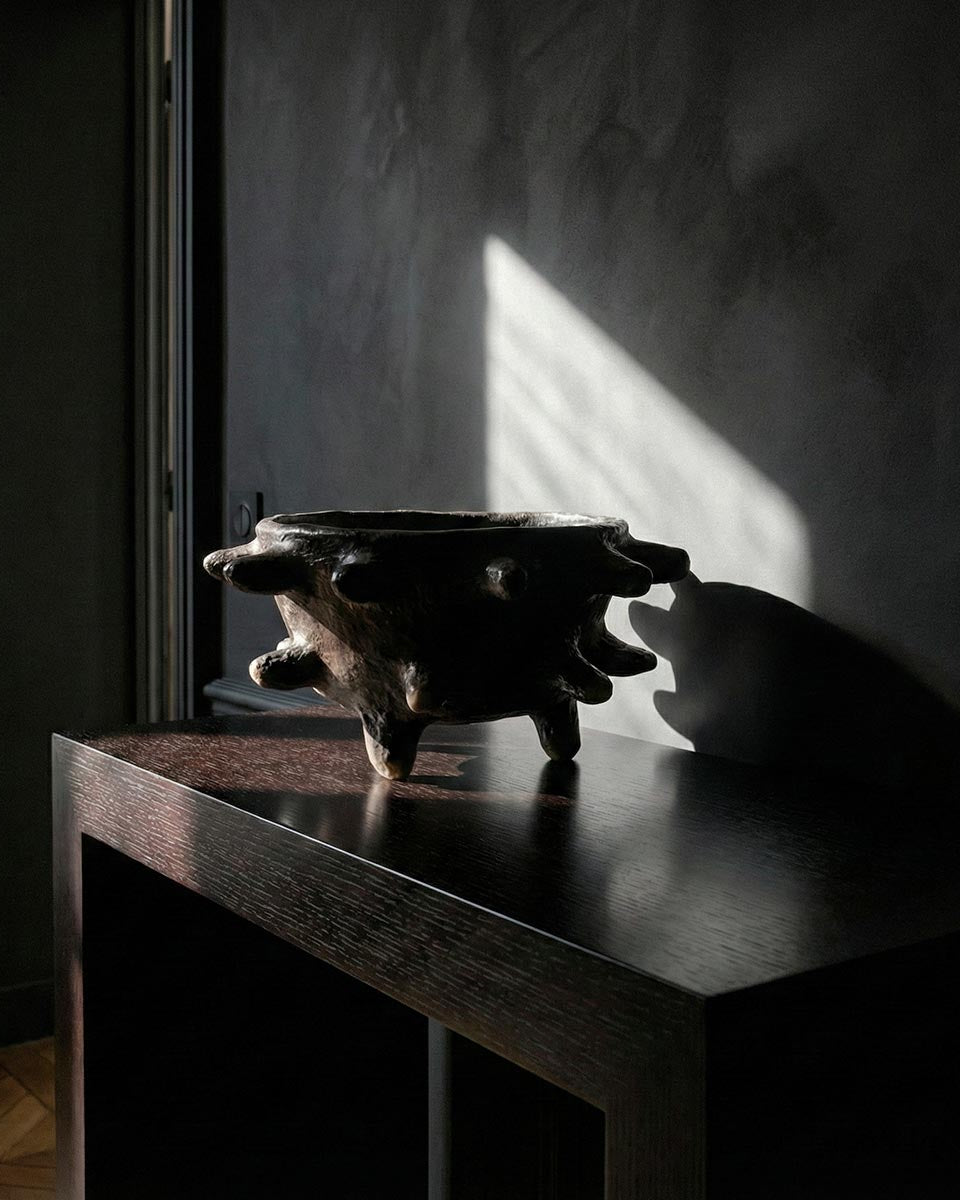 Grande ciotola scultura nera ambientata su un tavolo di design lussuoso