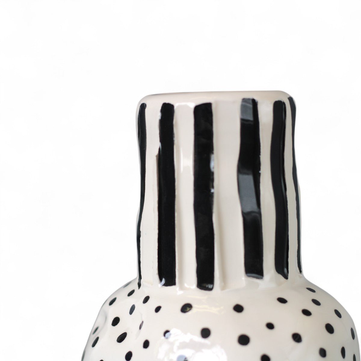 Dettaglio dei punti neri sparsi come note musicali sul vaso in ceramica.