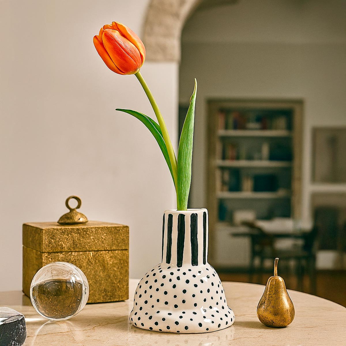 Il vaso in ceramica a righe esposto su una mensola come scultura di design.