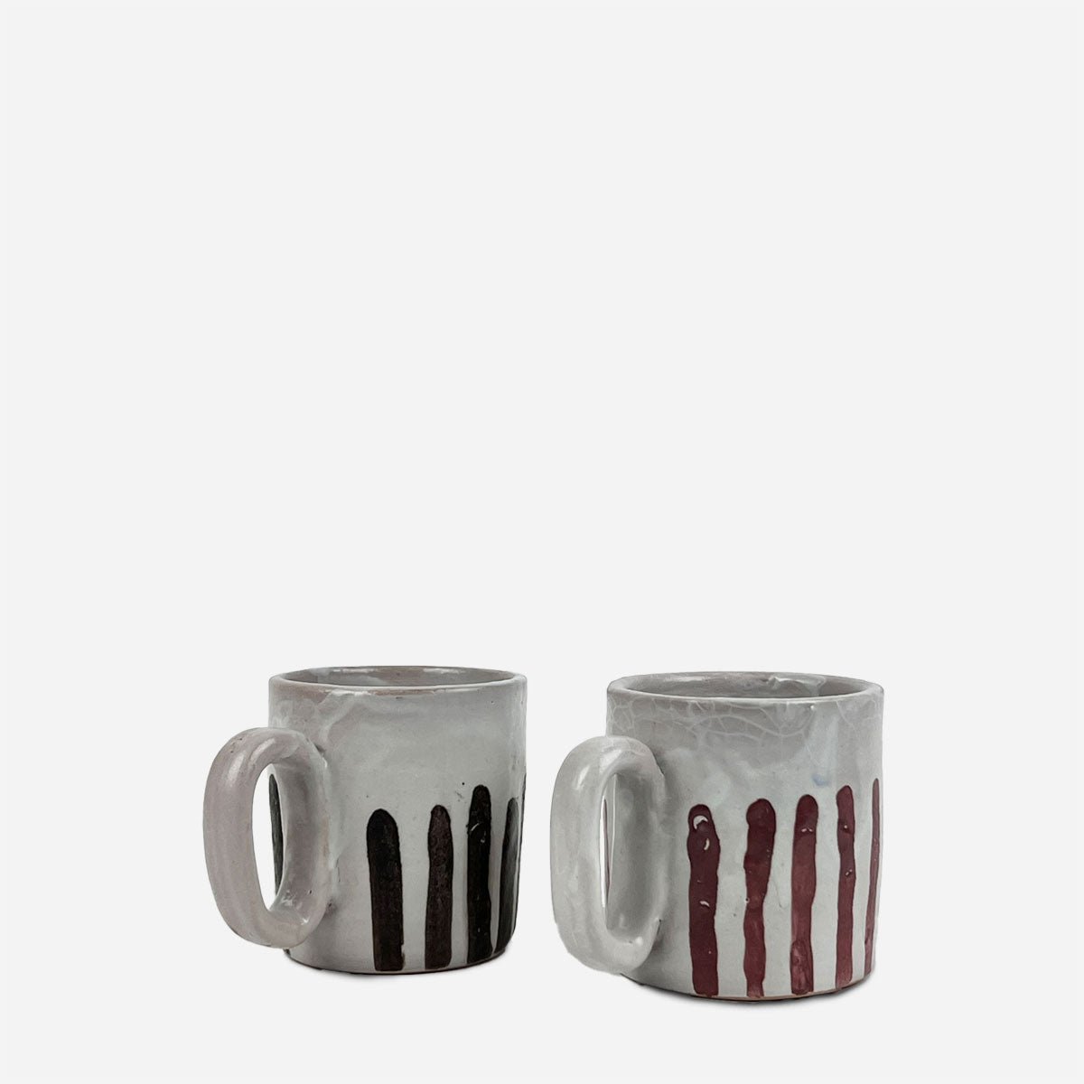 Coppia di tazze Blu e rubino in ceramica artigianale, decorate a mano con strisce blu e rosse.