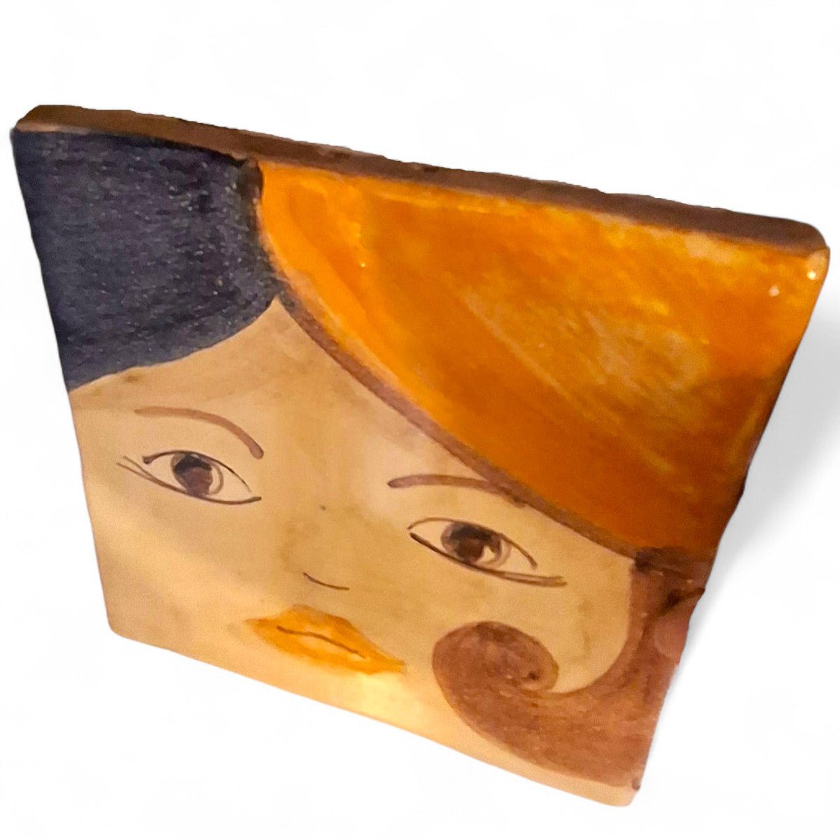 La coppia di mattonelle Idda & Iddu esposte in appoggio su una pila di libri d'arte.