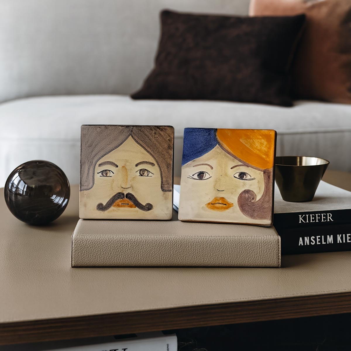 Primo piano del volto maschile (Iddu) sulla mattonella ceramica dipinta a mano.