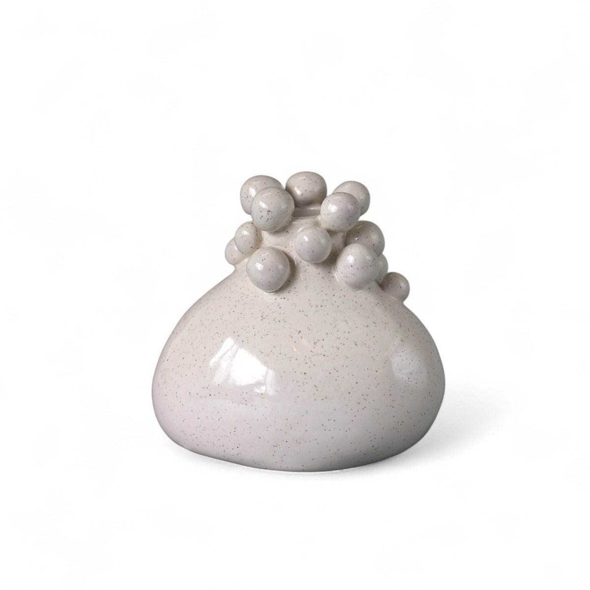 Il piccolo vaso in ceramica artigianale esposto su una mensola scura per esaltarne la forma.