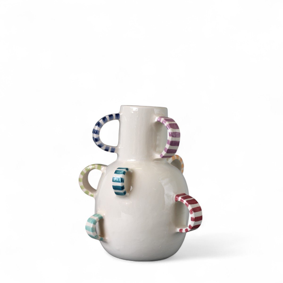 Il vaso in ceramica colorato esposto su una mensola bianca, che ne esalta la vivacità.