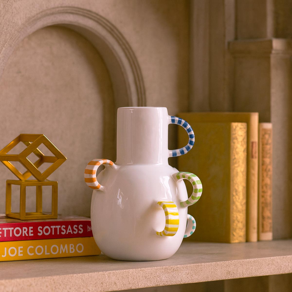 Primo piano delle maniglie multiple, disposte come piccole ali, sul vaso in ceramica.