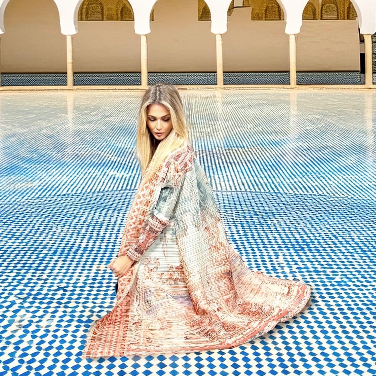 Dettaglio dei motivi nei toni del corallo e del rosa antico stampati sul kimono plissettato.