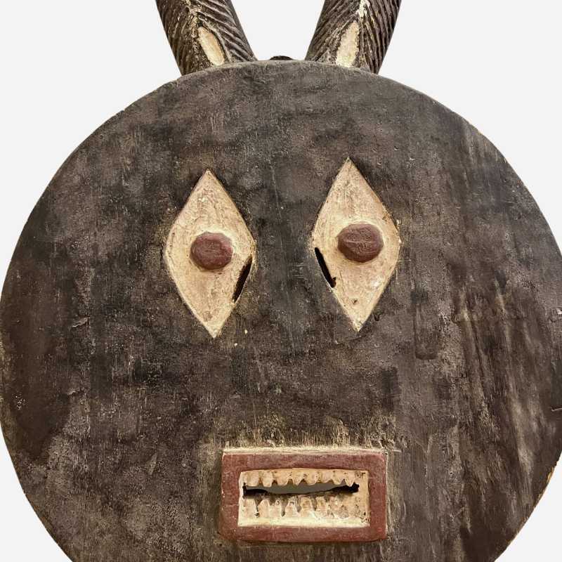 La Maschera Bwa appesa a una parete come pezzo centrale di una collezione di arte etnica.