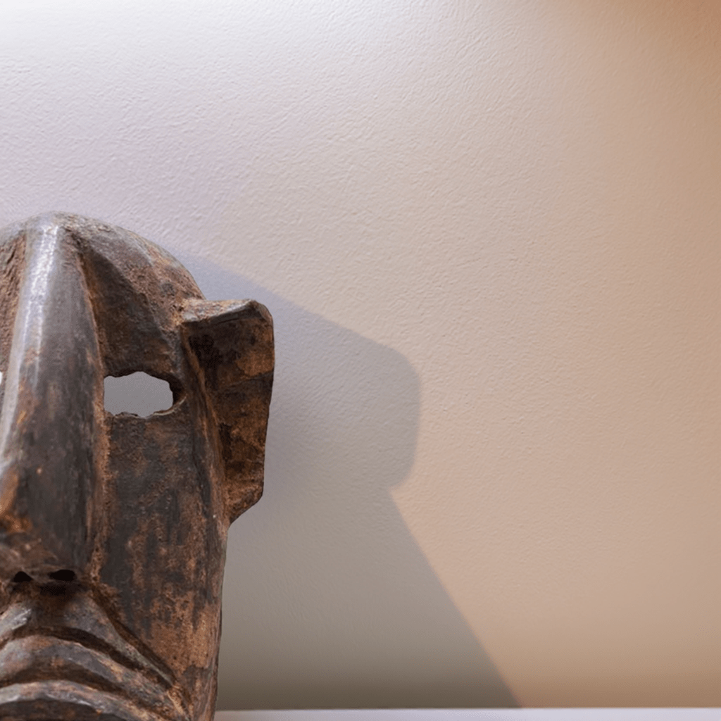 Primo piano dei motivi geometrici tradizionali intagliati sulla superficie della Maschera Dogon.