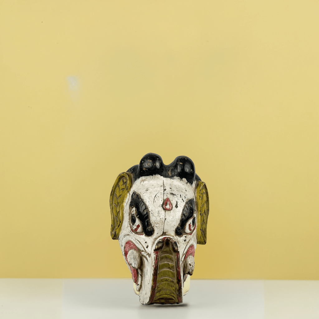 Dettaglio dei colori vivaci (rosso, giallo, bianco) dipinti a mano sulla Maschera di Ganesha