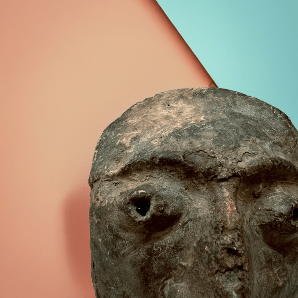 Primo piano delle crepe e della patina del tempo sulla superficie della Maschera Volto Arcaico.