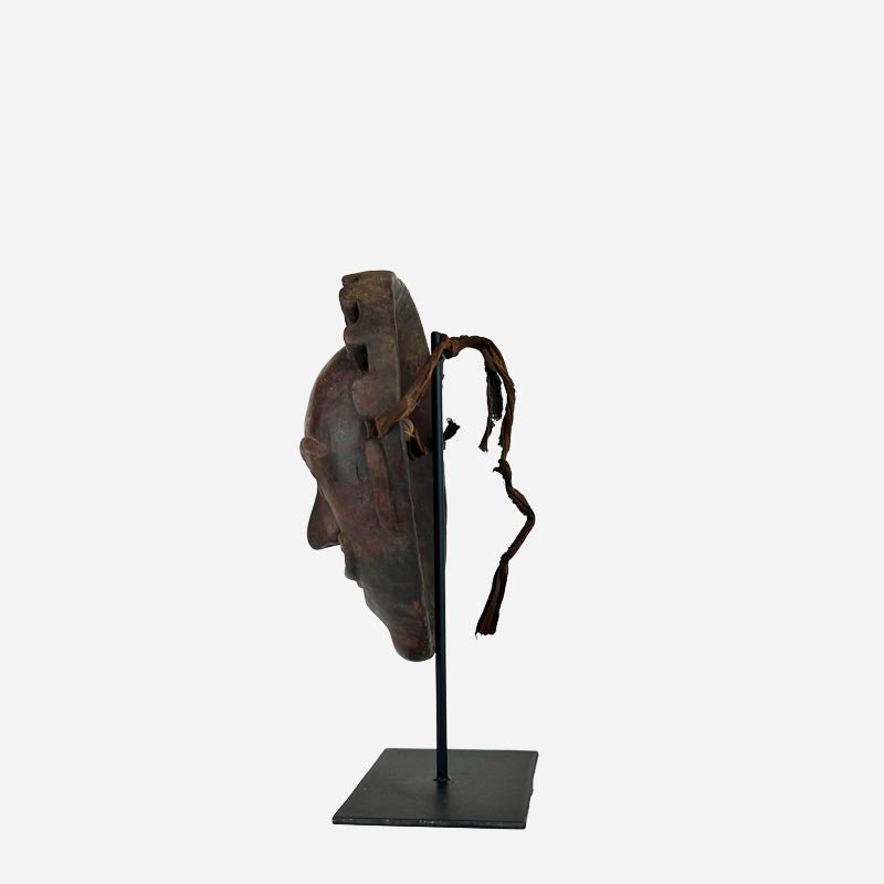 La Maschera Re Multiforme appesa come punto focale sulla parete di un salotto elegante.