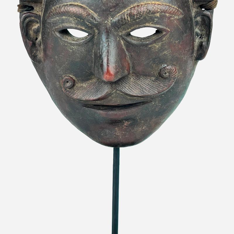 Primo piano della venatura calda e della finitura lucida del legno di mogano della maschera.