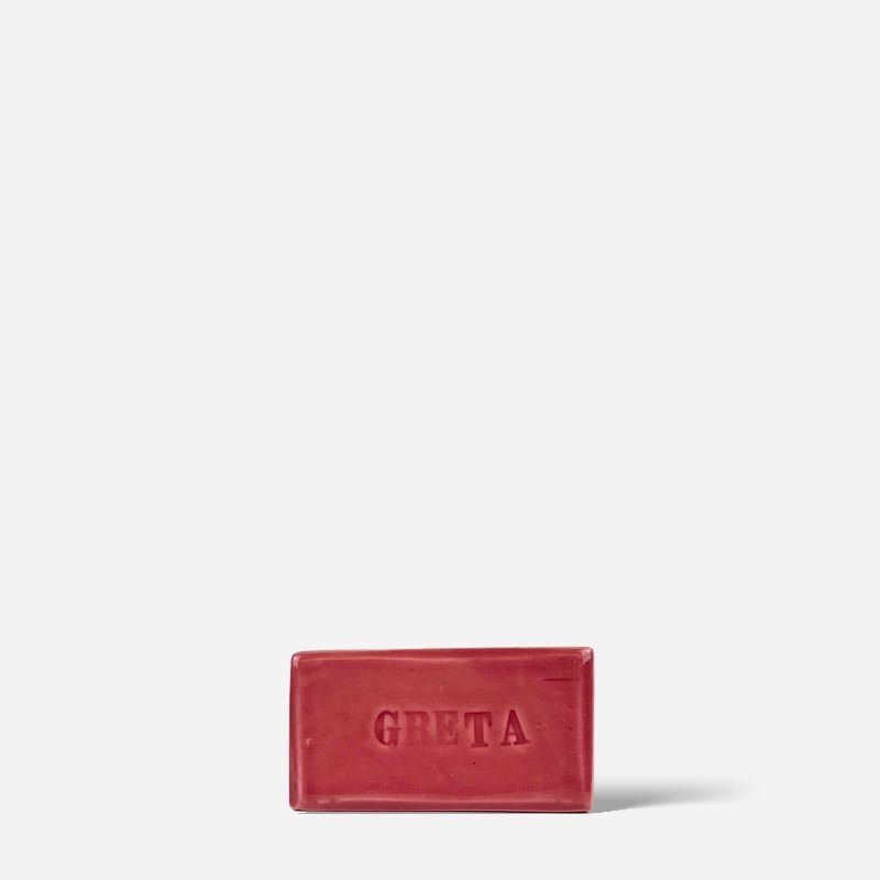 Dettaglio della fase di incisione del nome su un mattoncino di terracotta grezza.