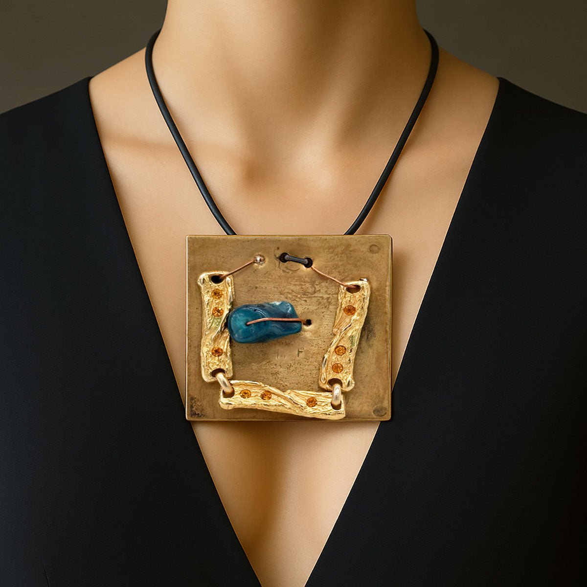 Monile Blu Vintage, gioiello artigianale con pietra blu centrale, placca in ottone e dettagli dorati.