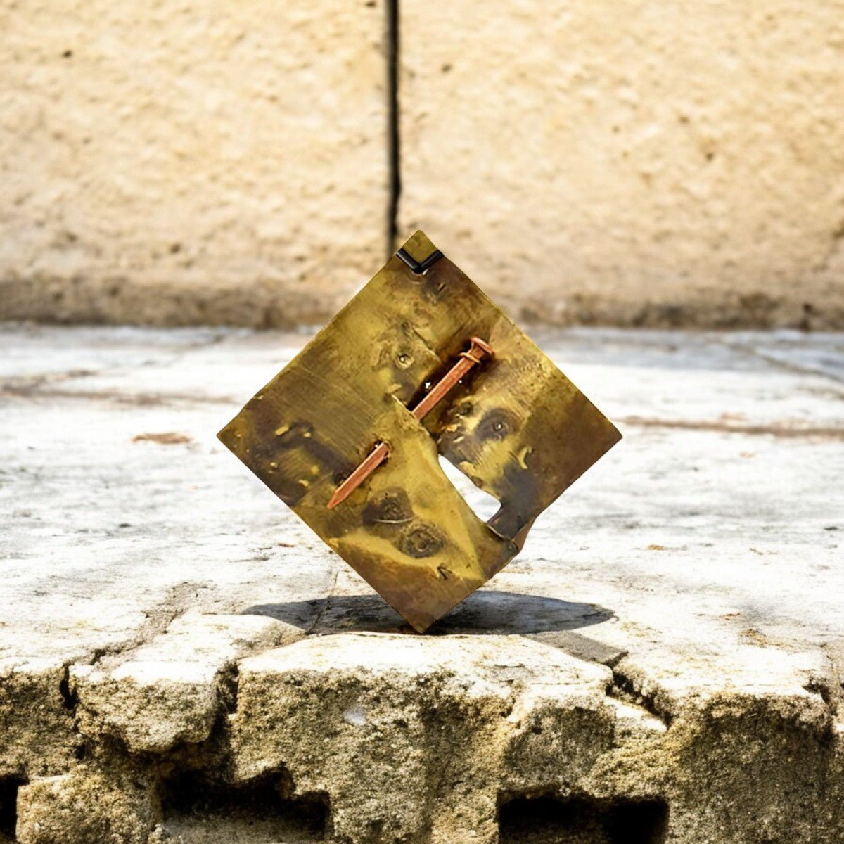 Dettaglio delle incisioni misteriose sulla placca in ottone lavorata a mano del monile.