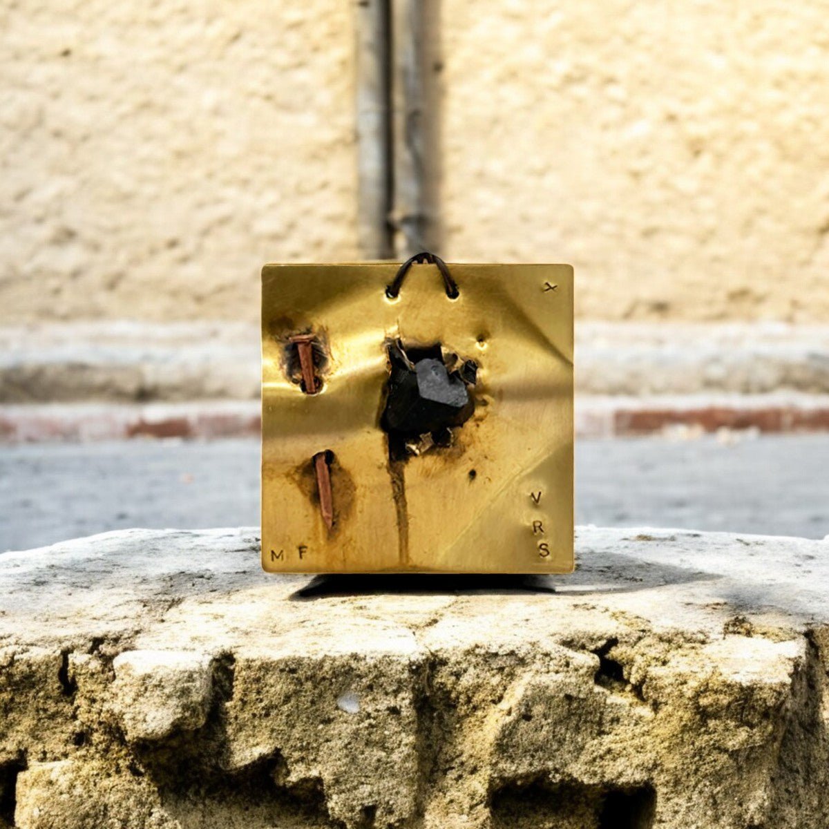 Dettaglio del chiodo fissato sulla placca in ottone del Monile Ombra Fratturata.