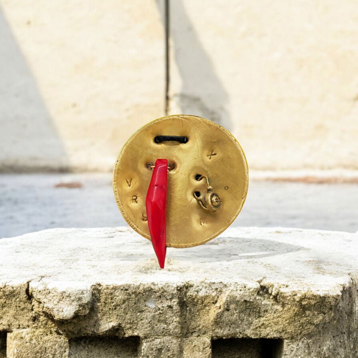 Dettaglio delle incisioni enigmatiche con lettere (V,R,S) sulla placca in ottone anticato.