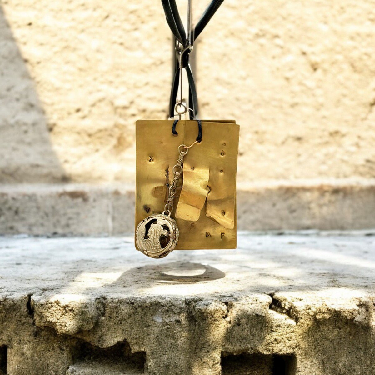 Dettaglio delle incisioni enigmatiche sulla placca in ottone lavorata a mano del Monile Sigillo Etrusco.