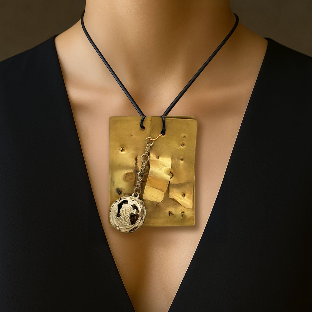 Monile Sigillo Etrusco, gioiello artigianale con placca in ottone, parte mobile e ciondolo.