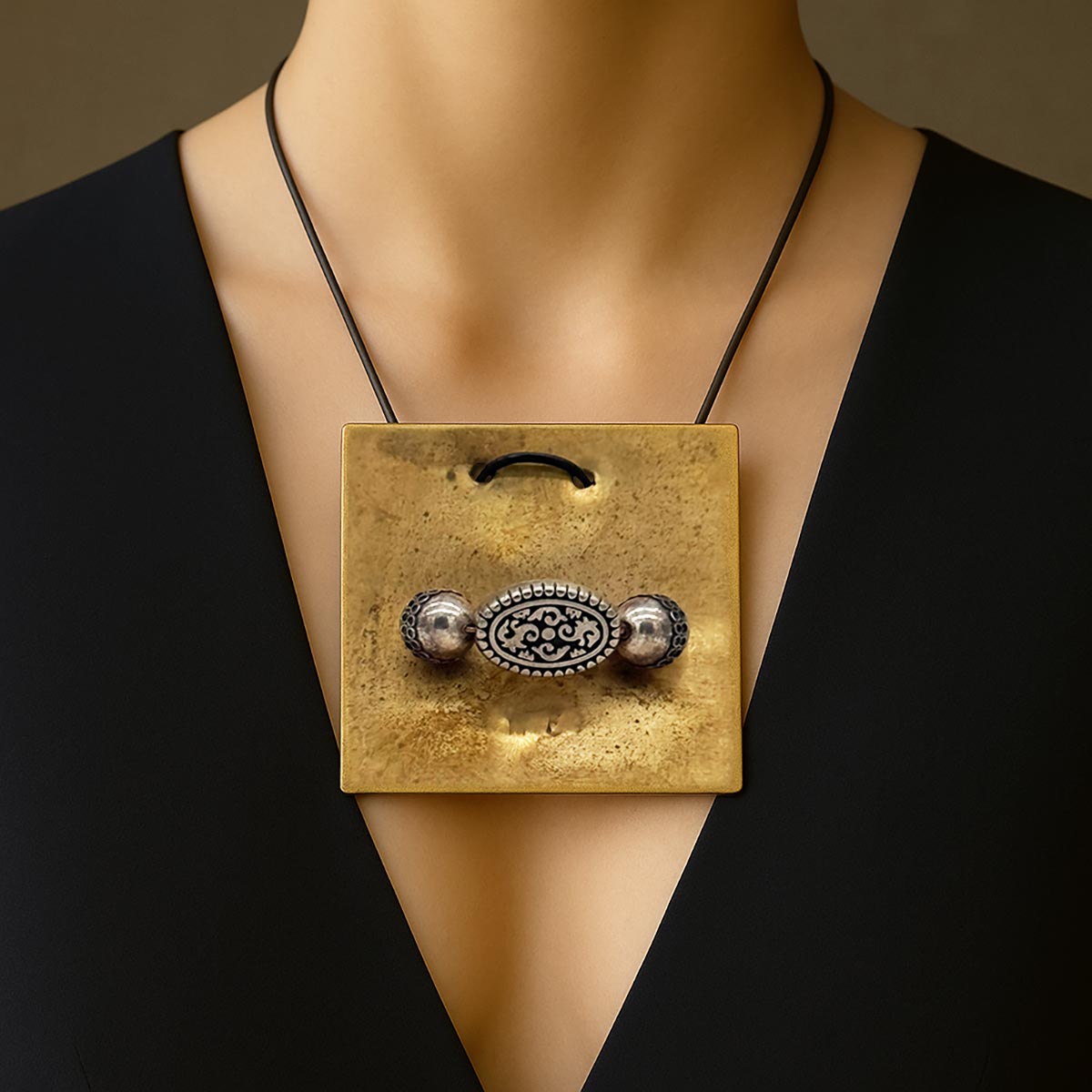 Monile Sigillo Ornato, gioiello artigianale in ottone con incisione centrale e sfere cesellate.