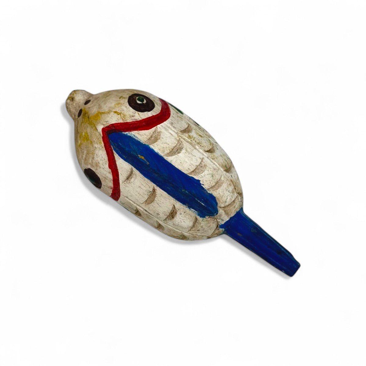 La scultura pesce in legno accanto a una tazza per un confronto delle dimensioni.