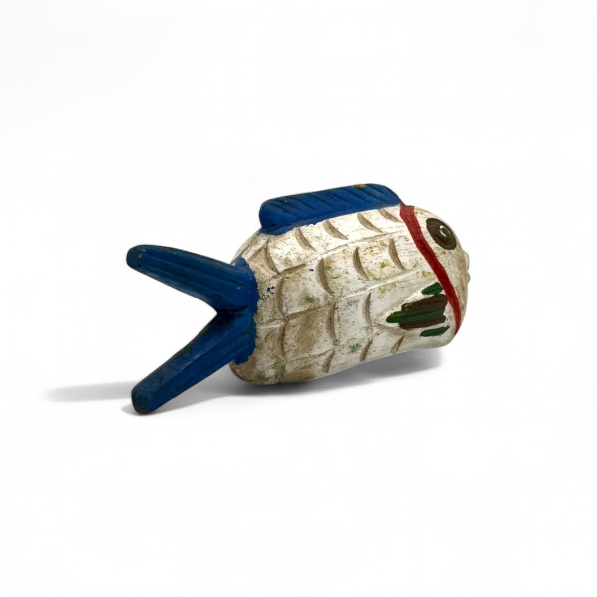 La scultura pesce in legno Pesce Memoria #1 esposta su una mensola bianca.