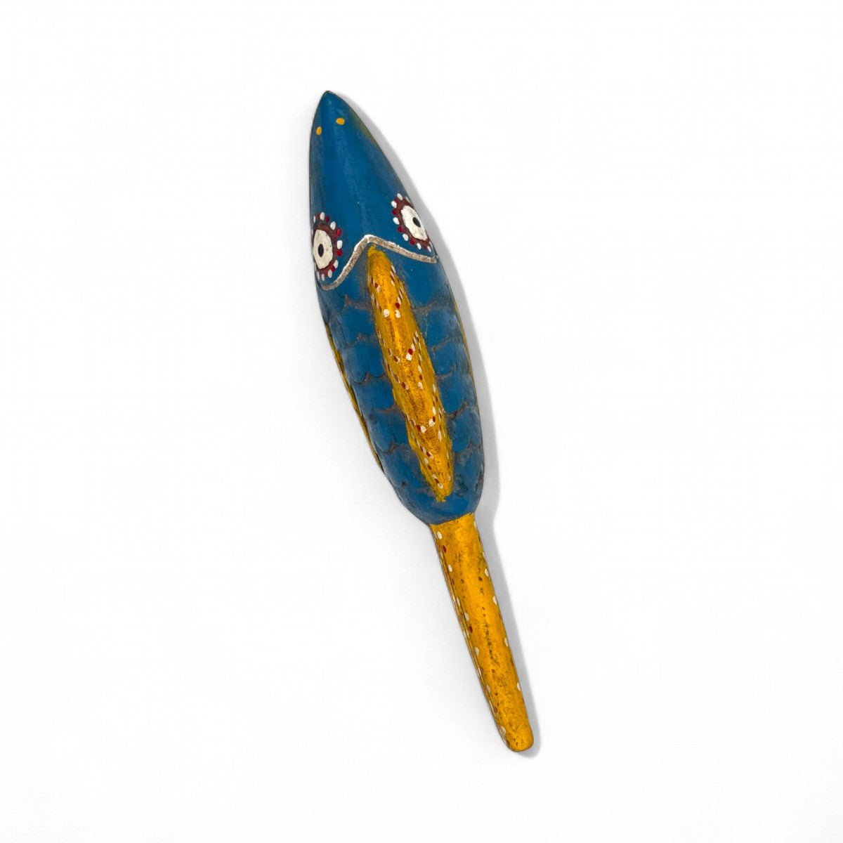 La scultura pesce in legno accanto a un oggetto per un confronto delle dimensioni.