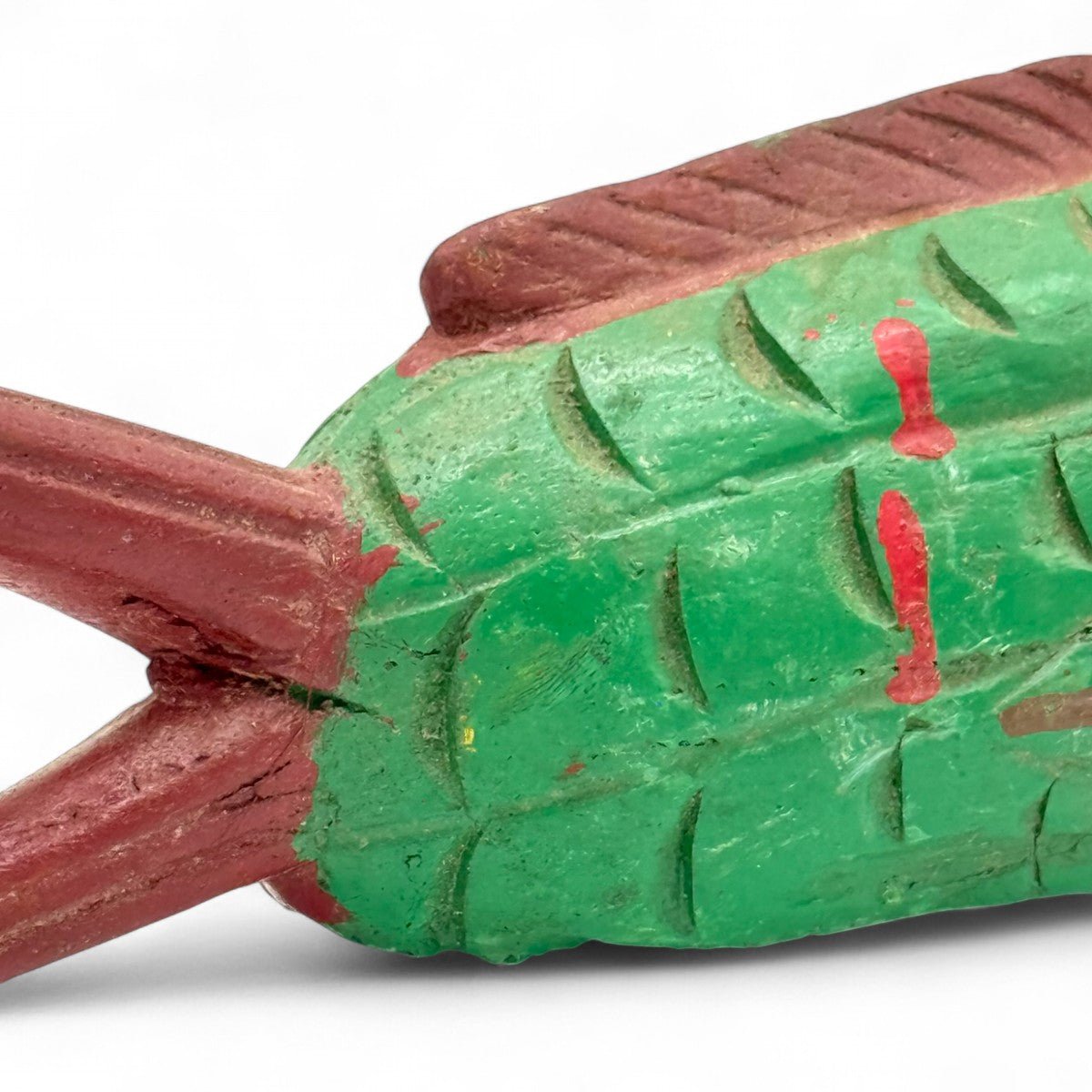 Mano che posiziona la scultura pesce in legno su una pila di libri d'arte.