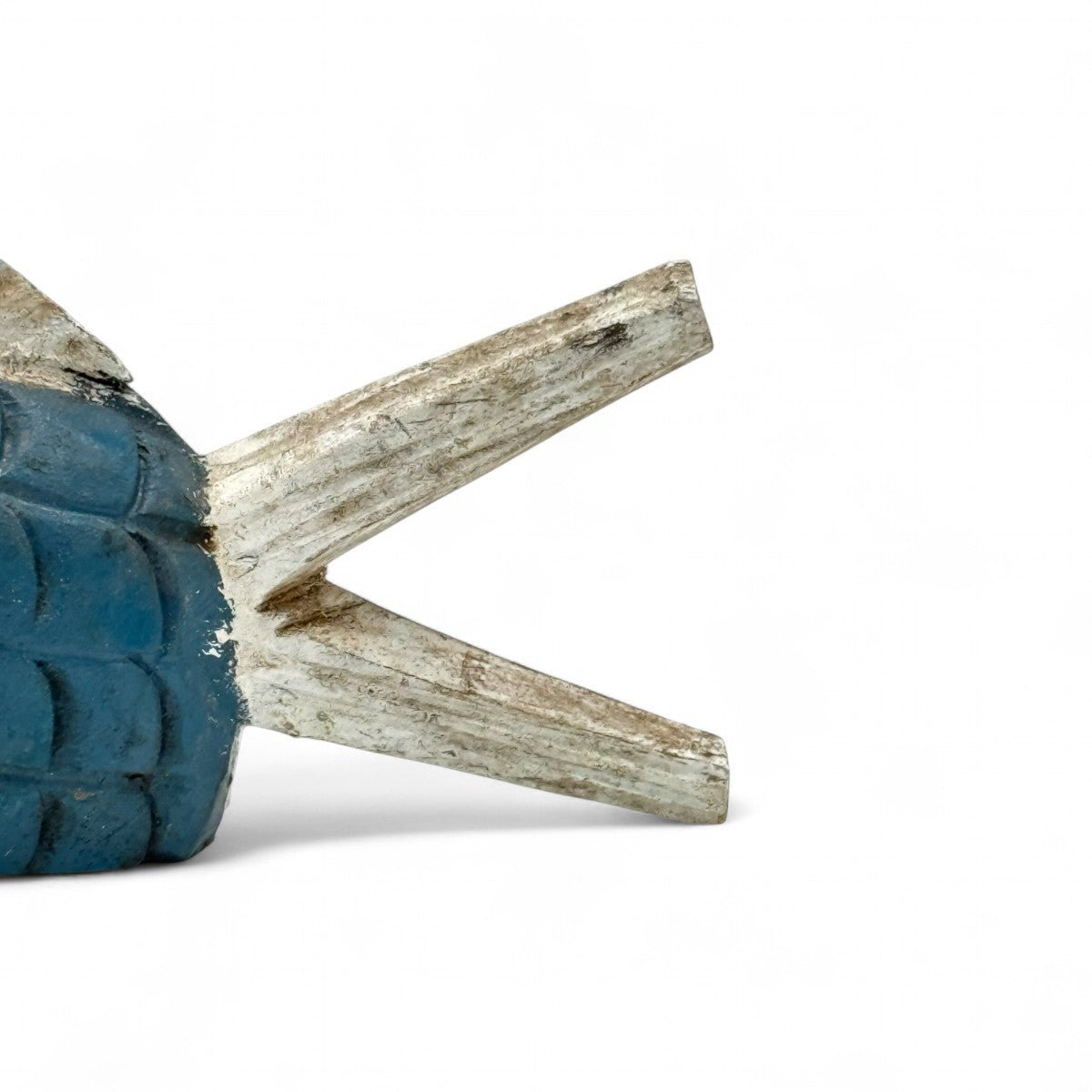 La scultura pesce in legno accanto a un oggetto per un confronto delle dimensioni.