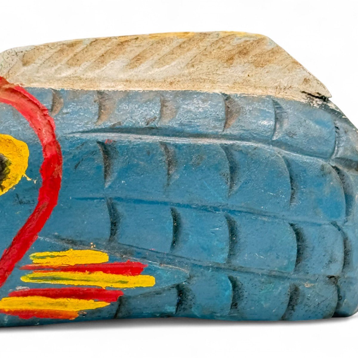 Profilo della scultura pesce in legno che ne mostra la forma irregolare e allungata.