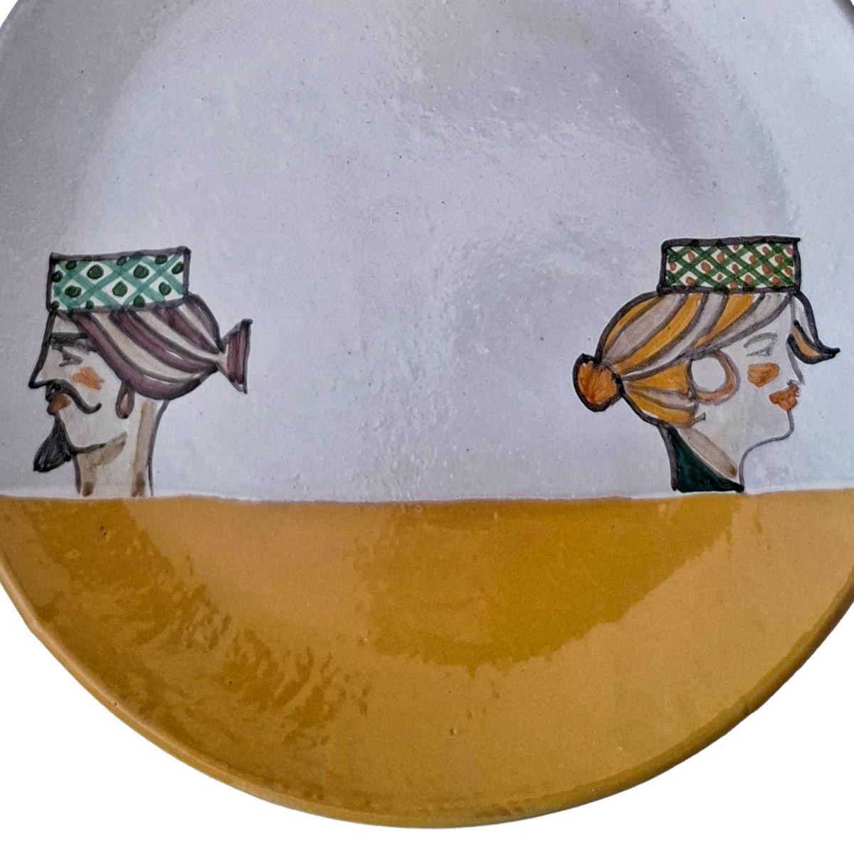 Primo piano dei due profili, dama e cavaliere, sul piatto maiolica dipinto.