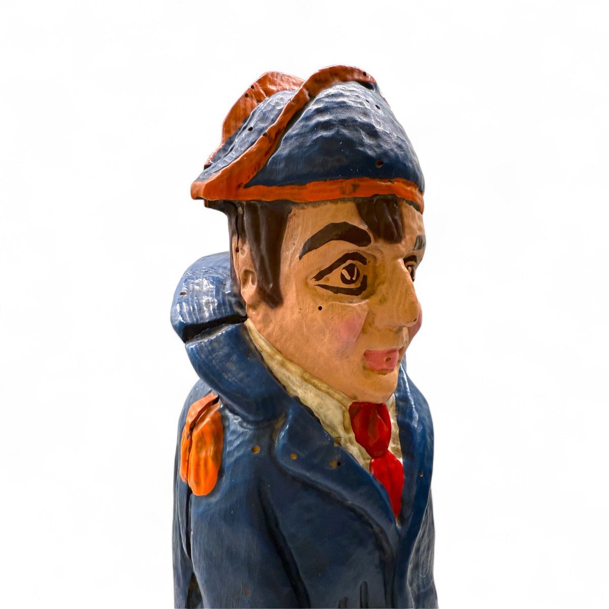 Primo piano del volto malinconico e umano della scultura di Napoleone in legno.