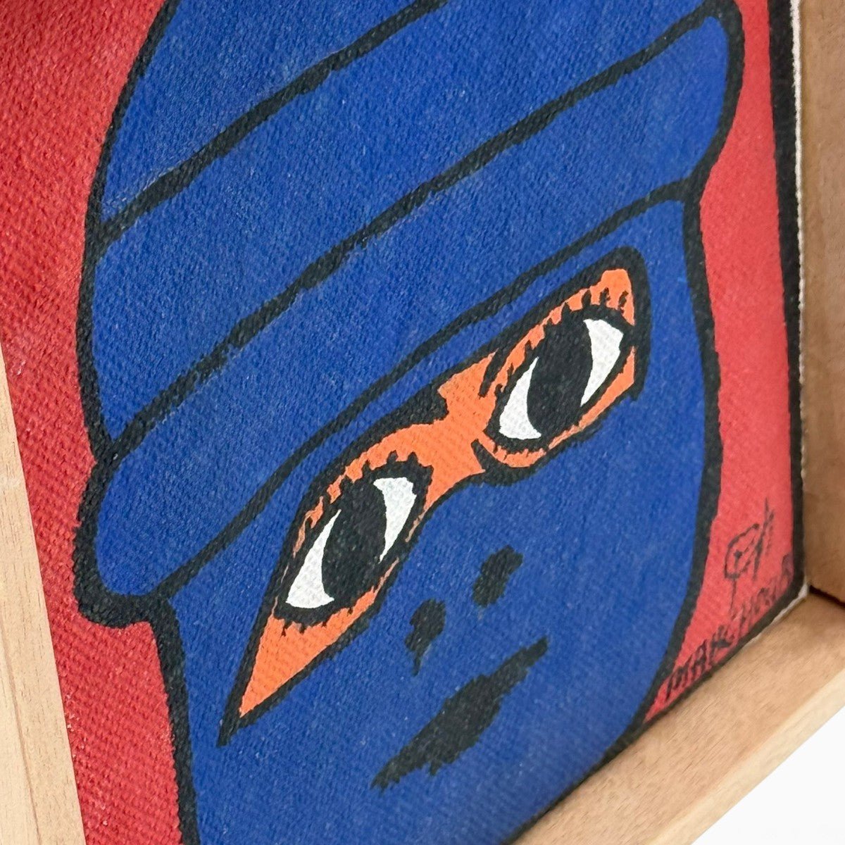 Particolare del copricapo blu e dello sfondo rosso scuro del quadro.