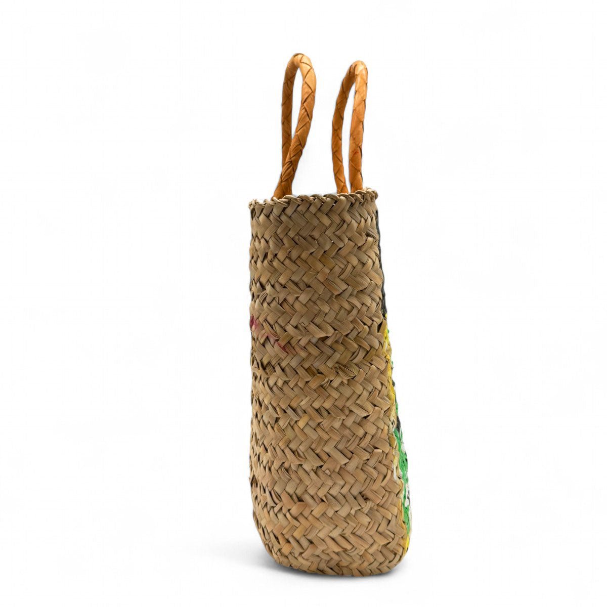 La borsa dipinta a mano La Scena Cubista posata su un muretto bianco a Santorini.