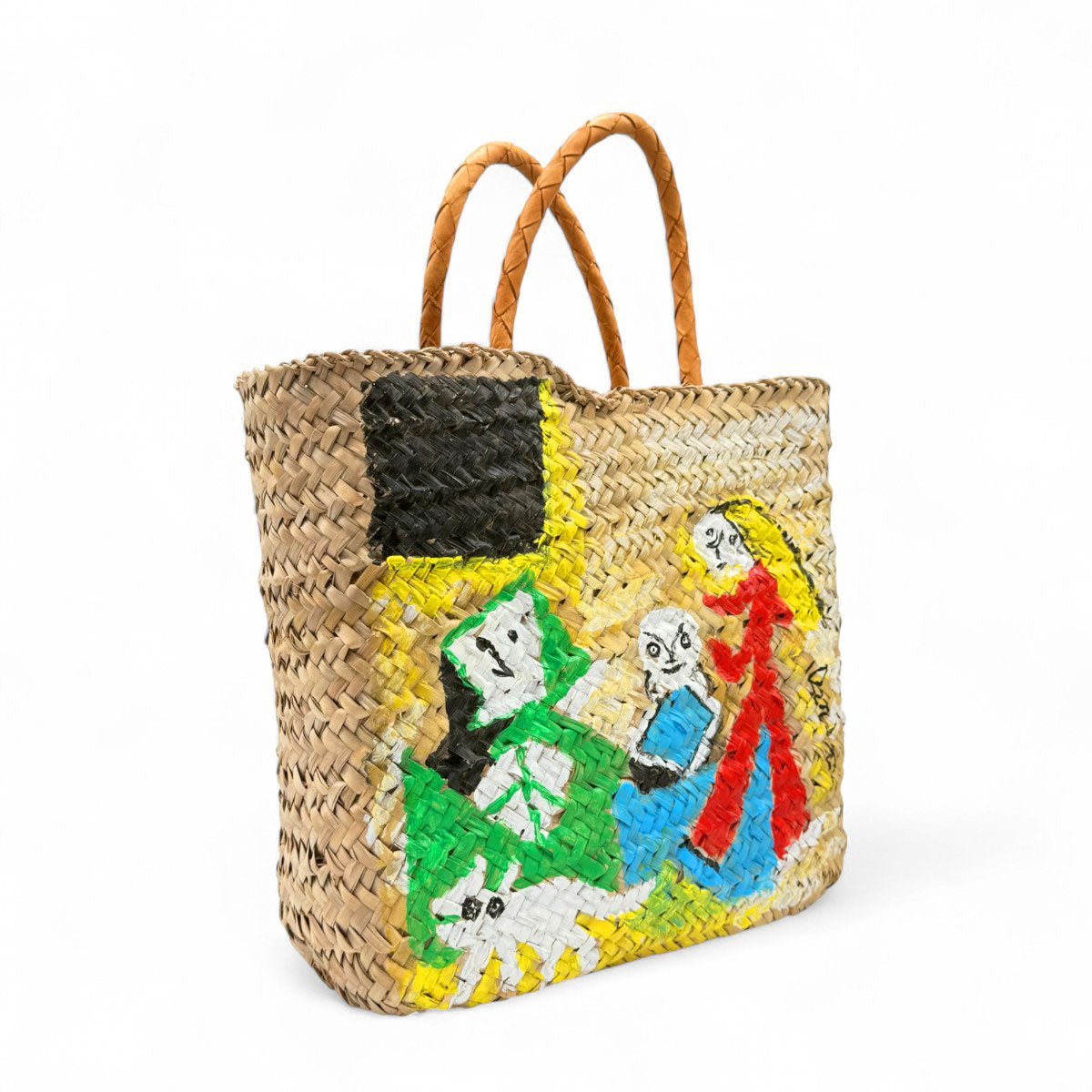 Modella indossa la borsa in paglia Santorini con un abito bianco, con le cupole blu sullo sfondo.