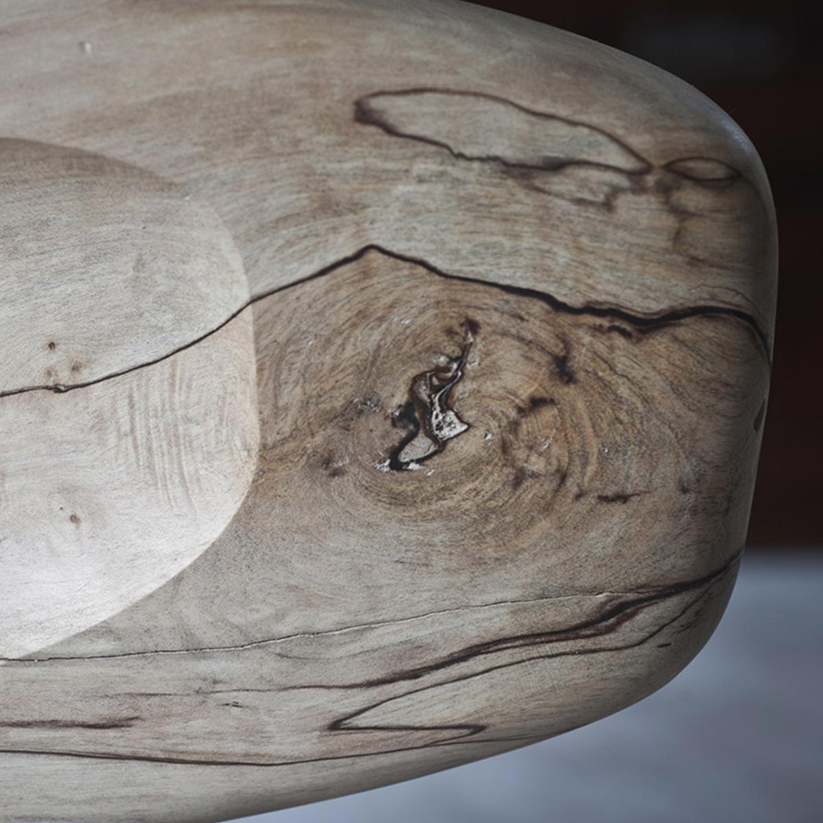 Profilo della scultura che evidenzia la sua forma fluida, le sue curve e il foro passante.