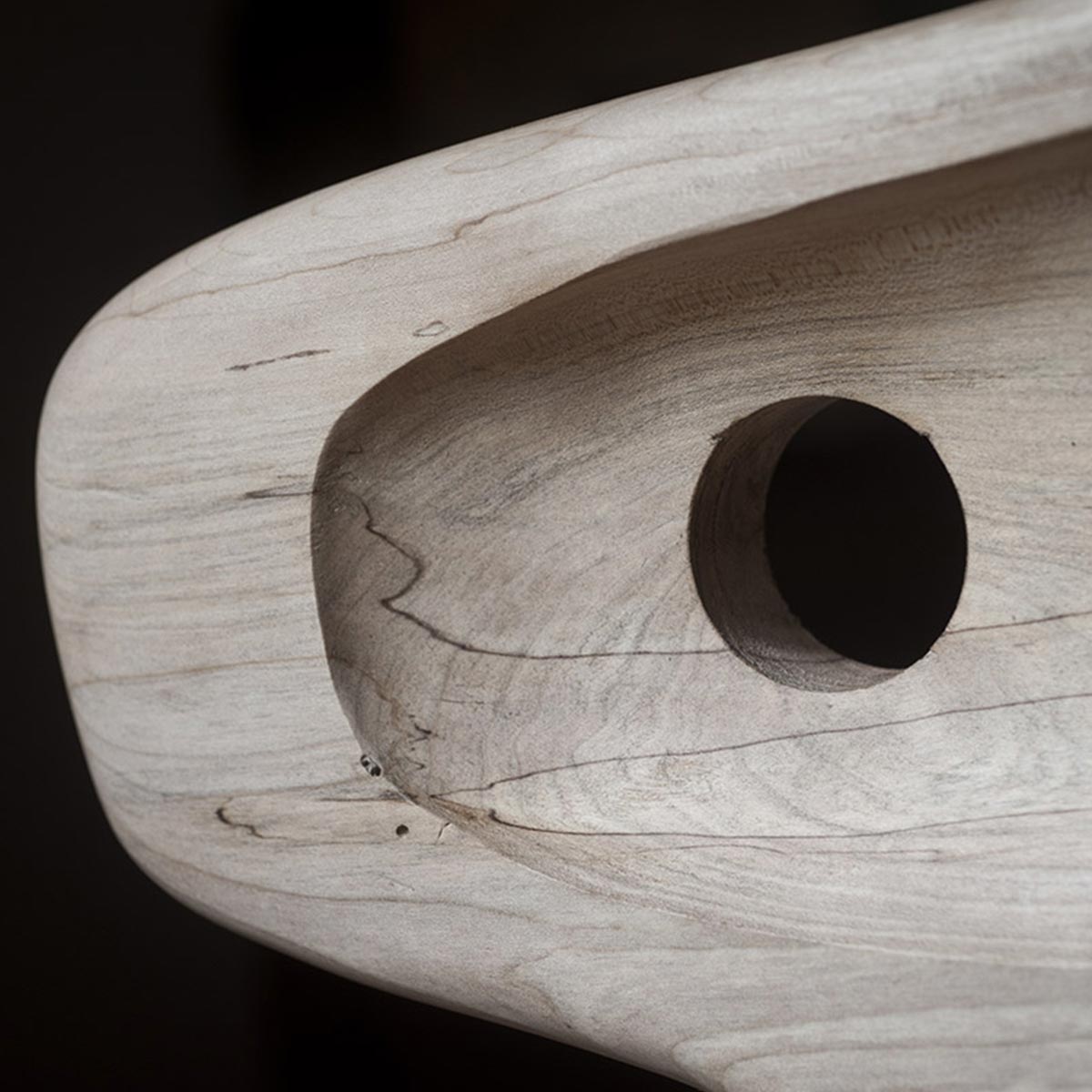 Primo piano della venatura naturale e del colore chiaro del legno di acero della scultura.