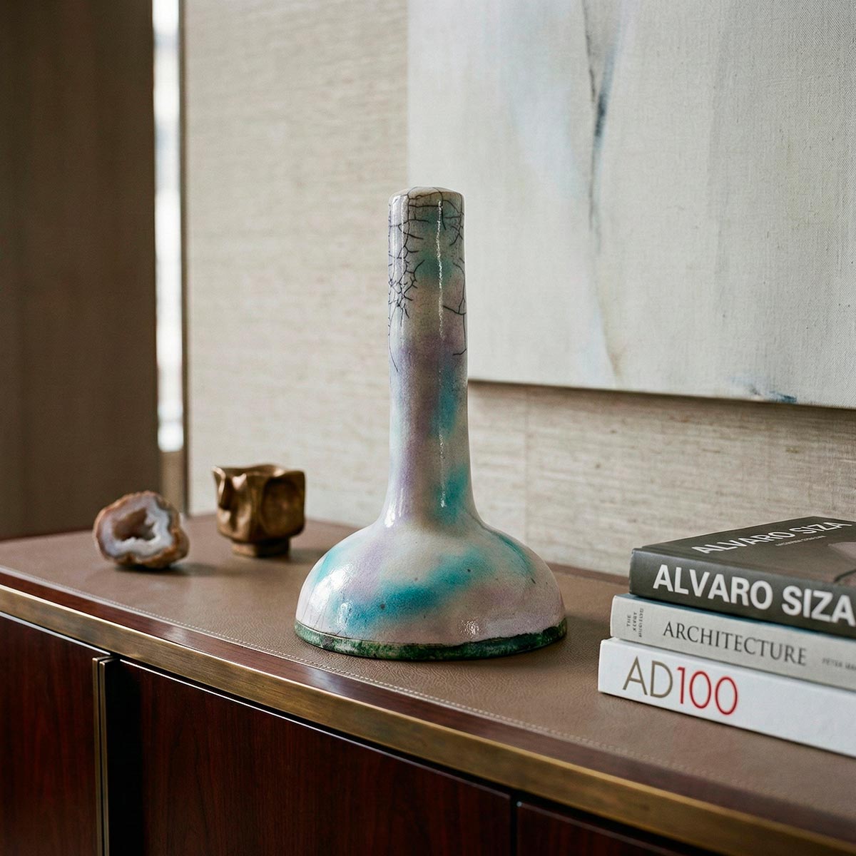 Scultura lampada ceramica raku con riflessi iridescenti pastello e craquelé nero.